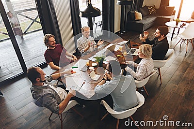 Coworking meeting. Group business people sits around table and w Stock Photo