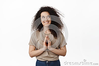Coy brunette girl scheming, having evil genius idea, steeple fingers and looking devious at upper right corner, smiling Stock Photo