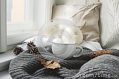 Cozy autumn morning breakfast in bed still life scene. Steaming cup of hot coffee, tea standing near window. Fall Stock Photo