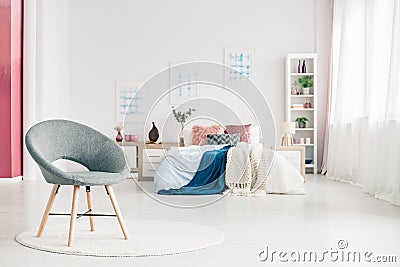 Cozy bedroom with grey chair Stock Photo