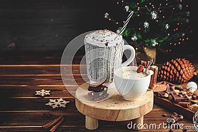 Cozy Christmas composition.Two mug with hot drinks, chocolate with whipped cream and cappuccino with cinnamon stick on a Stock Photo