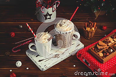 Cozy Christmas composition.Two mug with hot drinks, chocolate with whipped cream and cappuccino with cinnamon stick on a Stock Photo