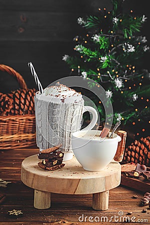 Cozy Christmas composition.Two mug with hot drinks, chocolate with whipped cream and cappuccino with cinnamon stick on a Stock Photo