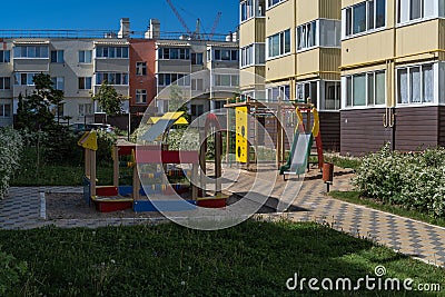 Cozy courtyard between houses with green plants and attractions for children. A wonderful space for outdoor recreation Stock Photo