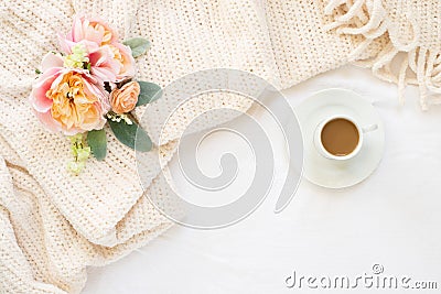 Cozy cream blanket on white bed with espresso and flowers Stock Photo