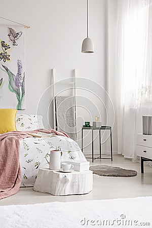 A cozy fresh bedroom interior in white with a bed dressed in sheets, pillows and blanket. Real photo. Stock Photo