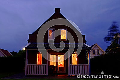 Cozy holiday home with veranda lighted by night Stock Photo