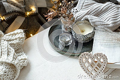 Cozy home composition with decorative wooden heart, candles and books Stock Photo