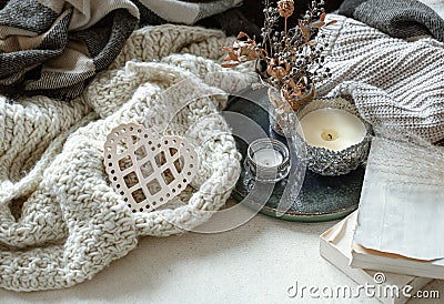 Cozy home composition with decorative wooden heart, candles and books Stock Photo