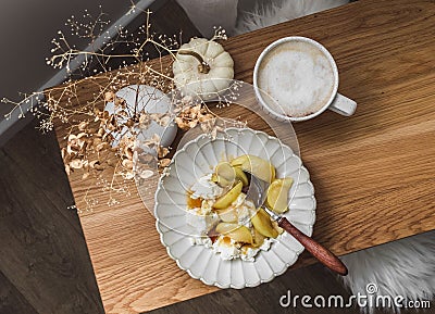 Cozy homemade morning and delicious breakfast - cottage cheese with caramelized apples and cappuccino on a wooden table Stock Photo