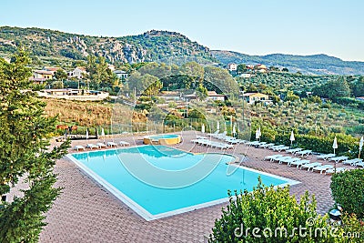 Cozy hotel lounge zone with swimming pool hidden among mountains Editorial Stock Photo