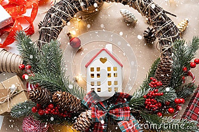 Cozy house in Christmas decor layout, warm knitted scarf, hat, winterization. Winter, snow - home insulation, protection from cold Stock Photo