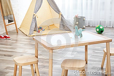 Cozy kids room interior with table, stools Stock Photo