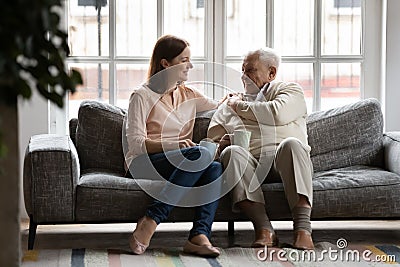 Caring adult daughter talking drinking tea with old father Stock Photo