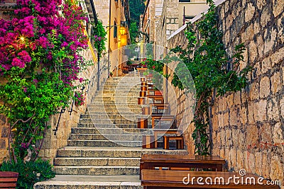 Narrow street and street cafe decorated with flowers, Hvar, Croatia Stock Photo