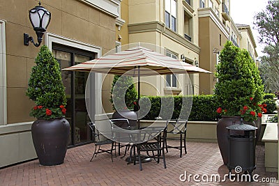 Cozy patio umbrella and table with chairs Stock Photo