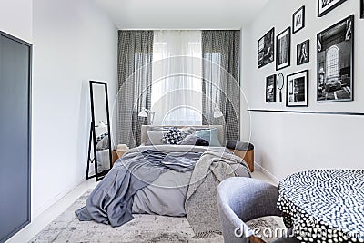 Cozy pillows on comfortable big king size bed in bright bedroom interior in elegant apartment Stock Photo