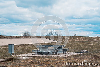 A cozy place for a picnic in the summer - wooden table, benches and trash can, near a campfire pit, Latvia Stock Photo