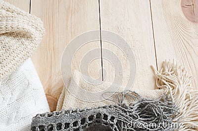 Cozy and soft winter background. Warm knitted clothes on a wooden background. Stock Photo