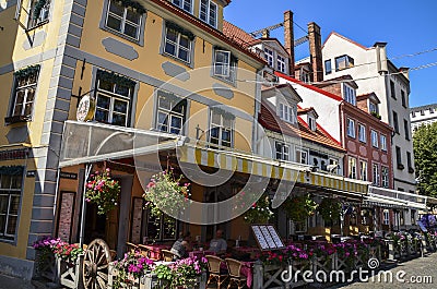 Cozy square with tables of decorated flowers street cafe in Riga, Latvia Editorial Stock Photo