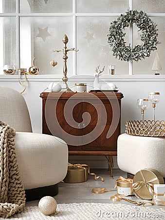 Cozy and stylish christmas living room interior with design armchair, retro shelf, poufm big window, christmas wreath, deer, gifts Stock Photo