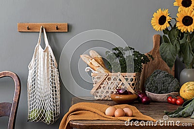 Cozy and stylish composition of creative dining room with mock up poter frame, wooden console, sunflowers and personal accessories Stock Photo