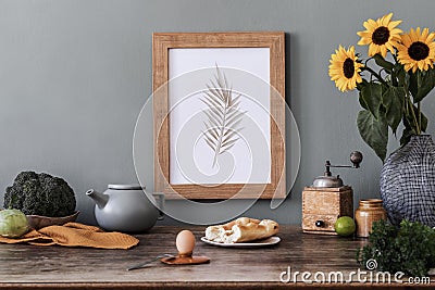 Cozy and stylish composition of creative dining room with mock up poter frame, wooden console, sunflowers and accessories. Stock Photo