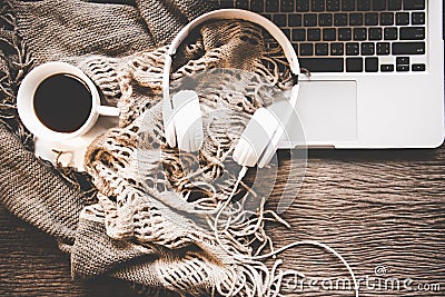 Cozy winter background, cup of hot coffee with marshmallow and headphone music, warm knitted sweater, work space laptop, Stock Photo