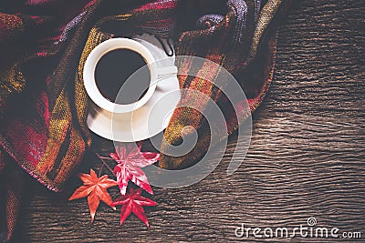 Cozy winter background, cup of hot coffee with marshmallow and leaves maple on season autumn, warm knitted sweater on old wooden b Stock Photo