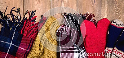 Cozy winter background Warm knitted scarfs and mittens on wooden background with space for text Top view. Copy space Long Toned Stock Photo