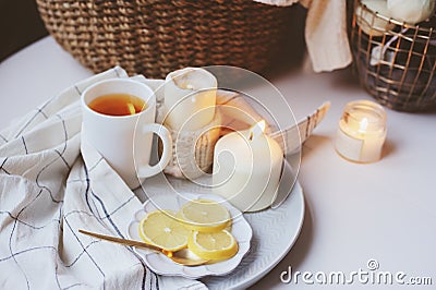Cozy winter morning at home. Hot tea with lemon, knitted sweaters and modern metallic interior details. Stock Photo