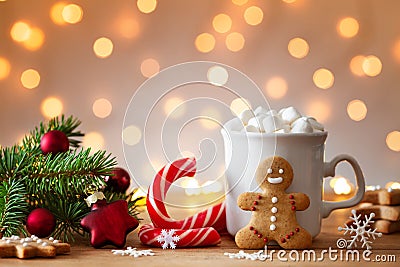 Cozy wintertime scene. Gingerbread man, cup of hot cocoa with marshmallow and Christmas fir branch Stock Photo
