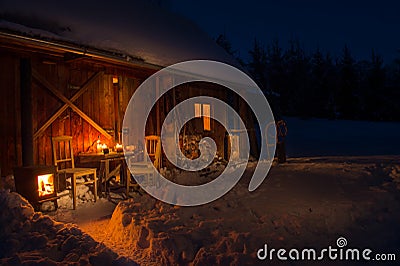 Cozy wooden cottage in dark winter forest Stock Photo