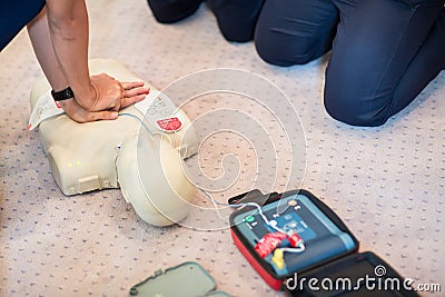 CPR training using and an AED and bag mask valve on an adult training manikin. Stock Photo