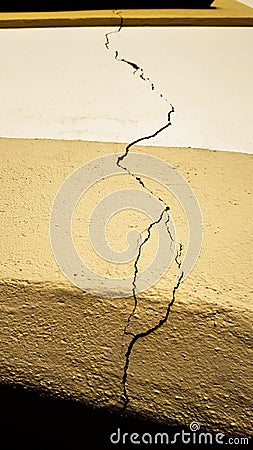 Crack on the building wall surface over the doors extending all the way to the window after an earthquake disaster Stock Photo