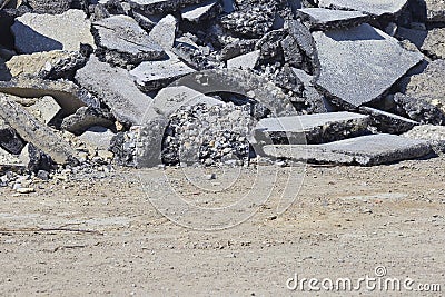 Cracked asphalt pieces after demolition of a road surface in a construction site Stock Photo