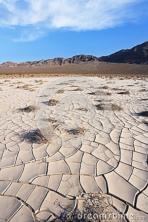 Cracked clay - takyr - surrounds a huge dune Stock Photo