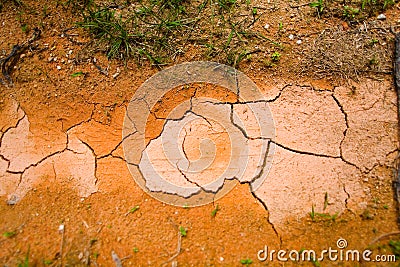 Cracked dry red earth with a track wheel protector. Stock Photo