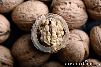 Cracked walnut with kernels on heap of whole walnuts Stock Photo