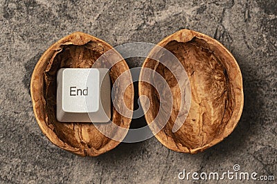 Cracked walnut shell with a END key of computer keyboard Stock Photo