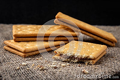 Cracker sandwiches with chocolate filling on black background. Stock Photo