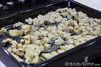 Crackers for Caesar salad. Pieces of bread on a baking sheet in Stock Photo