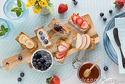 Crackers topped with fresh fruit, cream cheese or nut butter, ready for eating. Stock Photo