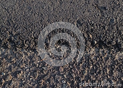 Cracking asphalt or imperfect asphalt patch on the edge. Full of small stone and sand. Stock Photo