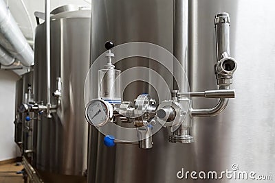 Craft beer brewing equipment in brewery. Metal tanks, alcoholic drink production. Facilities in modern interior of brewery. Manufa Stock Photo