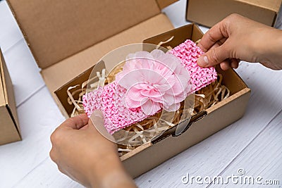 craft business - woman packing handmade baby floral headband in box for shipping Stock Photo