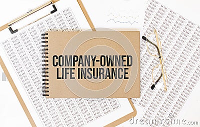 Craft colour notepad with text company-owned life insurance. Notepad with eyeglasses and text documents. Business concept Stock Photo