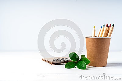 Craft paper coffee cup, pencils, green leaves sprout and recycled stationery. School Zero waste, eco friendly, natural organic Stock Photo