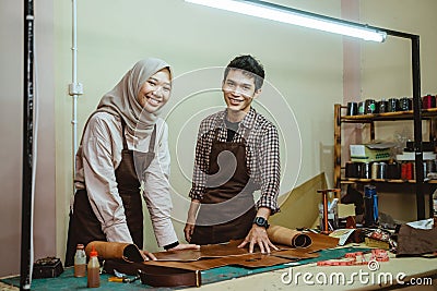 craftman and craftwoman in veil smiling at the camera Stock Photo