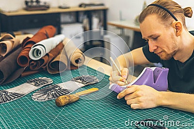 Craftsman drawing shoe last pattern creating leatherwork at studio leather workshop Stock Photo